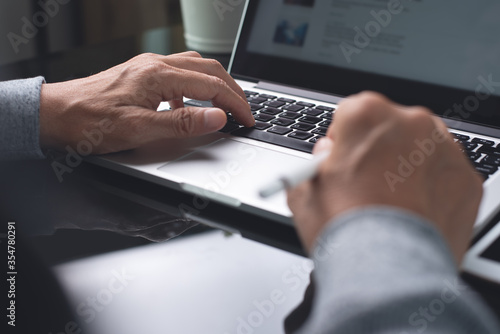 Man hand typing on laptop computer surfing internet online working 
