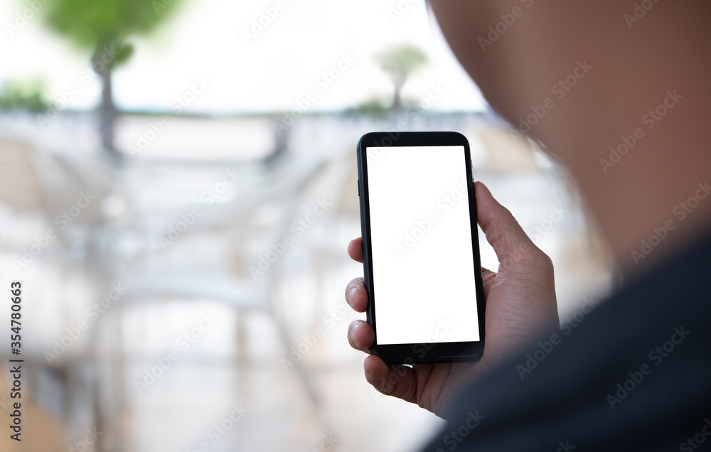 Mockup of man hand holding mobile phone in coffee shop or restaurant Mockup of man hand holding mobile phone in coffee shop or restaurant