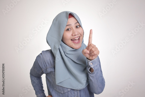 Asian Muslim Woman Smiling and  Raising Pointing Finger, Number One