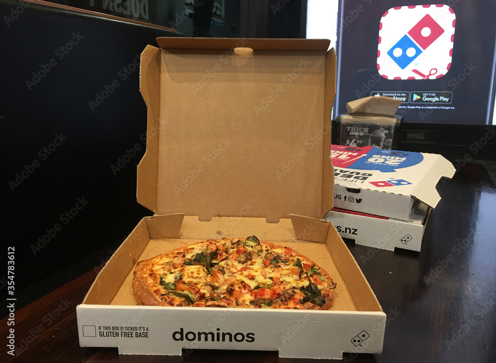 Open Domino's Pizza takaway box on a table Photos | Adobe Stock