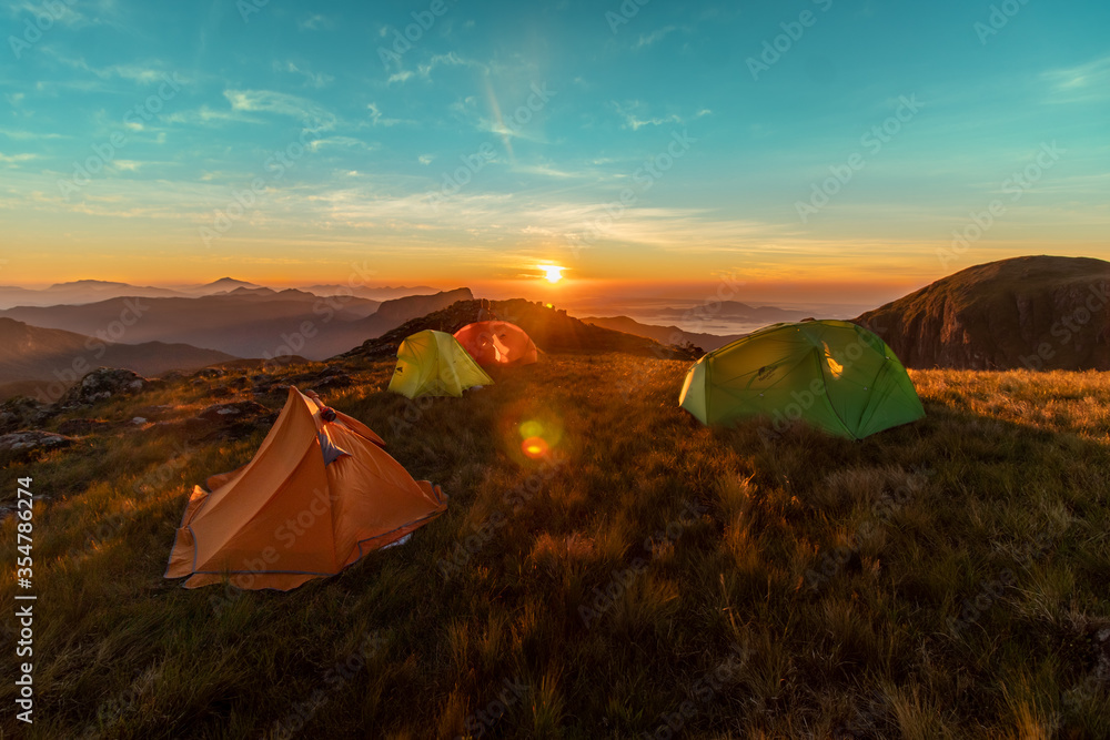Nascer do sol sobre as montanhas Campos do Quiriri com barracas de camping