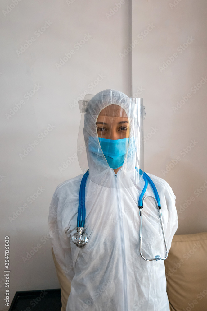 A young doctor in a biological protective suit and a stethoscope. Concept of pandemic A young doctor in a biological protective suit and a stethoscope. Concept of pandemic