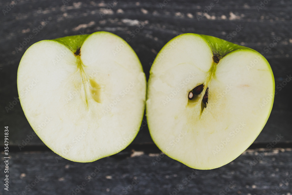 food ingredients concept, green apple cut in half on wooden table food ingredients concept, green apple cut in half on wooden table