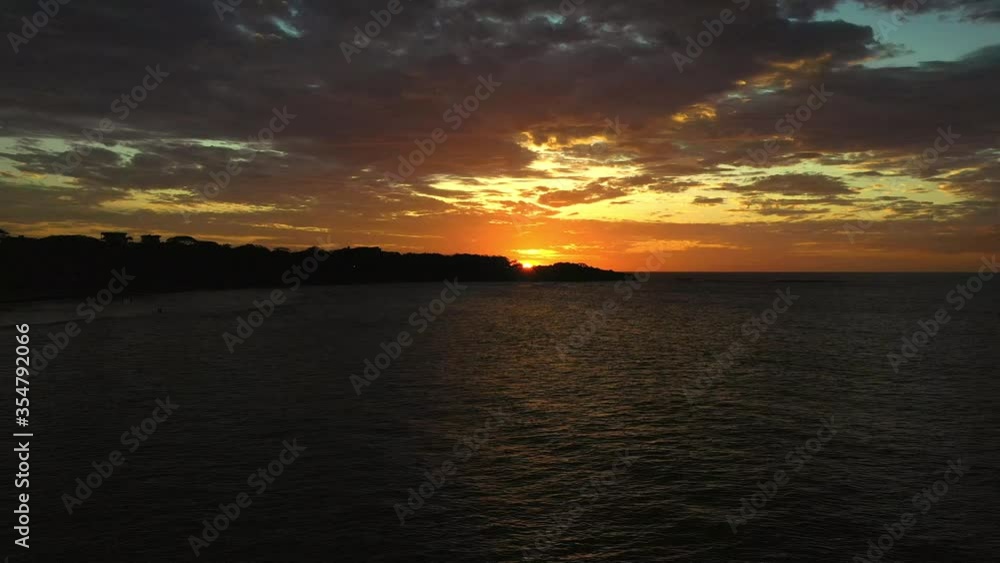 Beautiful sunset hiding behind a canopy of trees. Sunset on the horizon on a private beach in Costa Rica. Beautiful sunset hiding behind a canopy of trees. Sunset on the horizon on a private beach in Costa Rica.