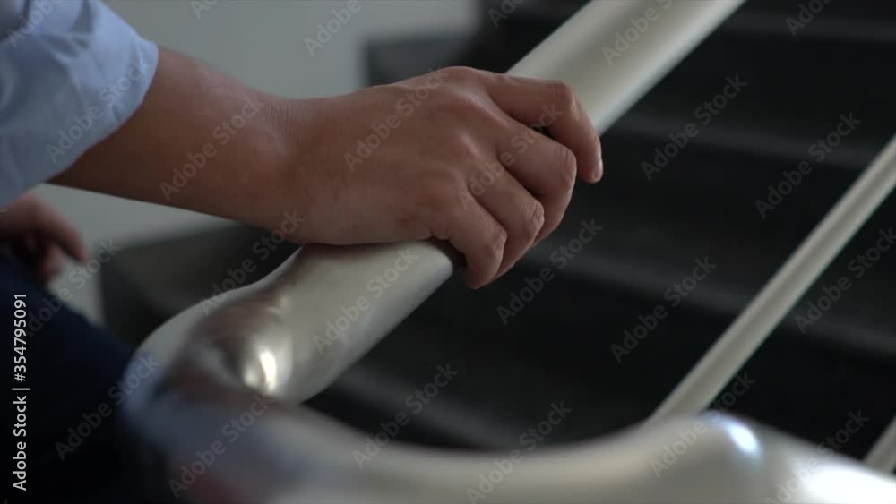 Hand holding banisters, The germ spread from person to person through direct physical contact for prevent the spread of the Covid-19 virus Hand holding banisters, The germ spread from person to person through direct physical contact for prevent the spread of the Covid-19 virus
