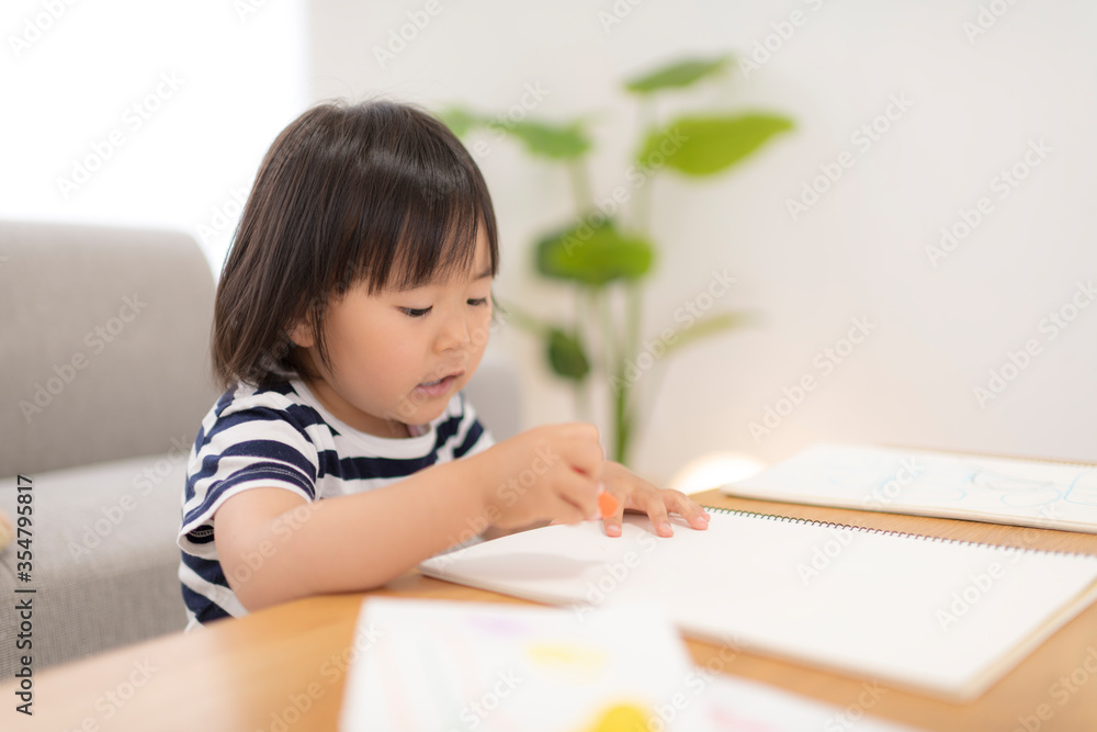 リビングでお絵かきしている3歳の女の子