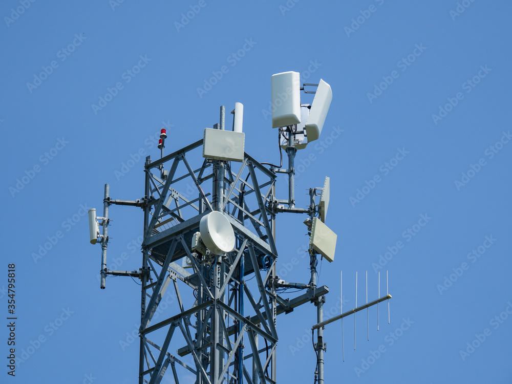Group of antennas, satellite dishes for telecommunications, television broadcast, cellphone on mountain peak. Electromagnetic and environment pollution