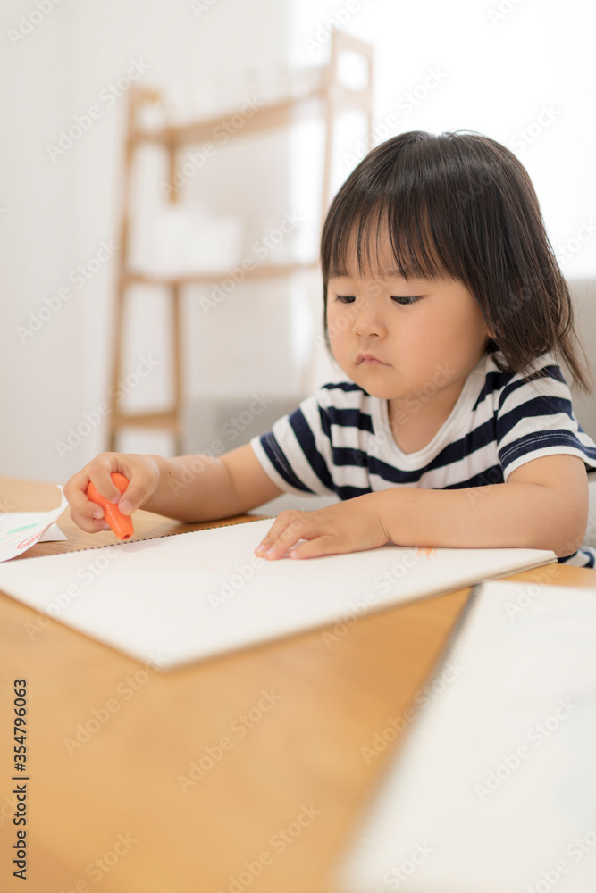 リビングでお絵かきしている3歳の女の子