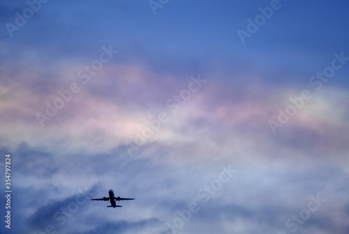 cloud iridescence during sunset with airplane / rainblow color of sky for envronment, travel and space design background