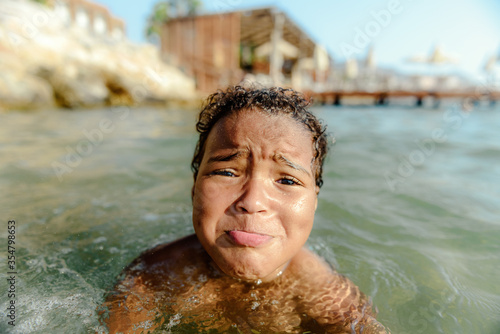 Little girl in danger drowning at the ocean.