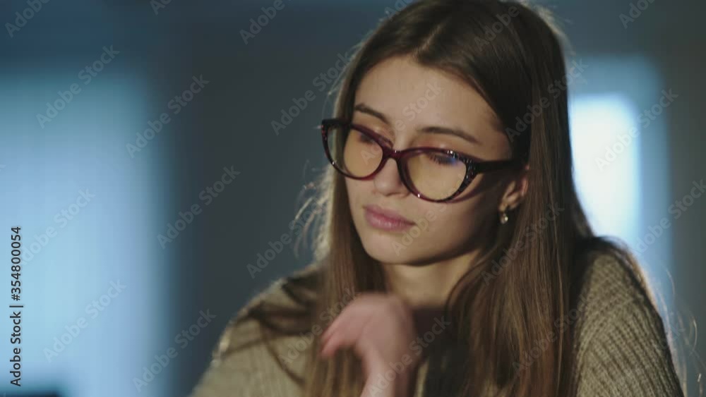 Tired student notes at desk, takes off glasses and thinks when leaning on hand Tired student notes at desk, takes off glasses and thinks when leaning on hand