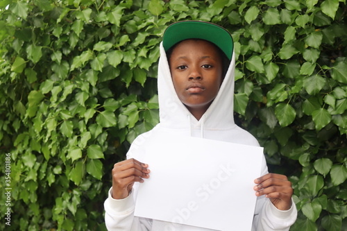 Young boy holding black white paper sign