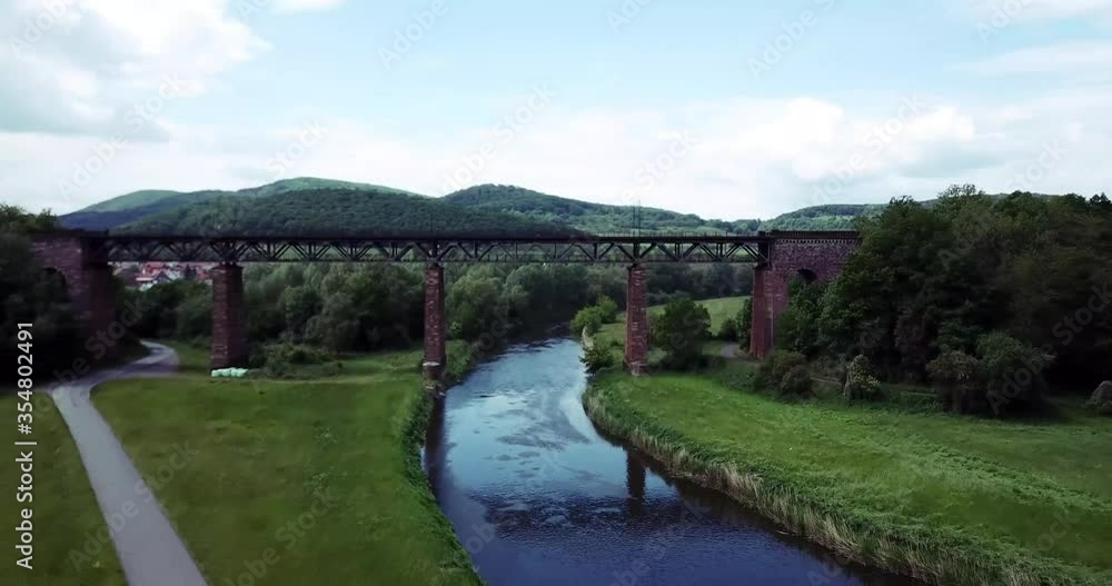 Bridge at a river with a railway by drone on a cloudy day. Shot i Germany. Bridge at a river with a railway by drone on a cloudy day. Shot i Germany.