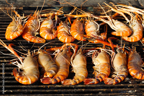 grilling giant prawn on outdoor hot stove 