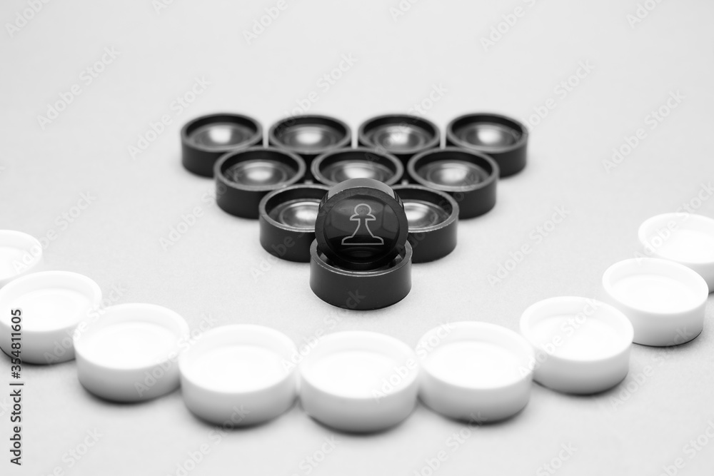 Faces on checkers in the form of facial expressions that reflect emotions. The concept of racism, misunderstanding, a barrier in relations, the denial of society. Barriers between people. Faces on checkers in the form of facial expressions that reflect emotions. The concept of racism, misunderstanding, a barrier in relations, the denial of society. Barriers between people.