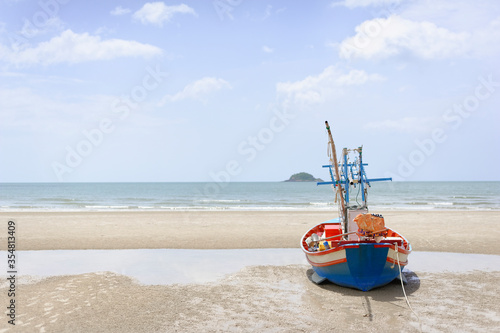 The fishing boat is parked by the blue sea at Hua Hin ,Thailand. Good for postcard or background.