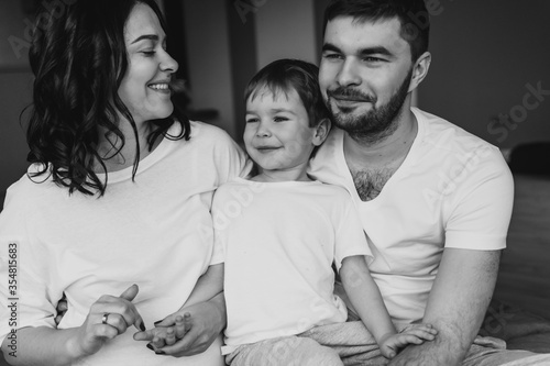 Close up portrait. Attractive young family with a child at home. Black and white photo. Smiling people