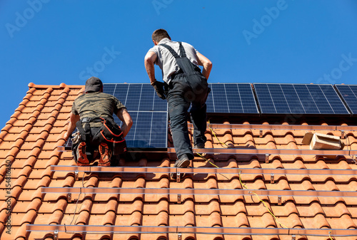 Wallpaper Mural  Workers installing solar electric panels on a house roof in  Ochojno. Poland Torontodigital.ca