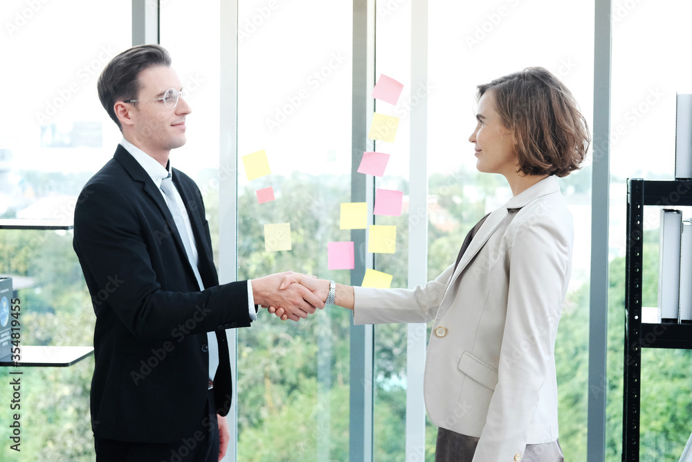 Successful businessman and businesswoman happy and shake hands after meeting for partnership in modern office Successful businessman and businesswoman happy and shake hands after meeting for partnership in modern office