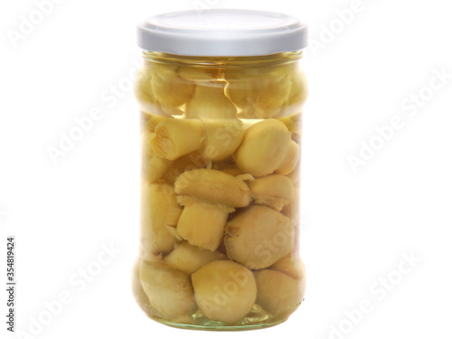 Canned mushrooms in a glass jar isolated on white background
