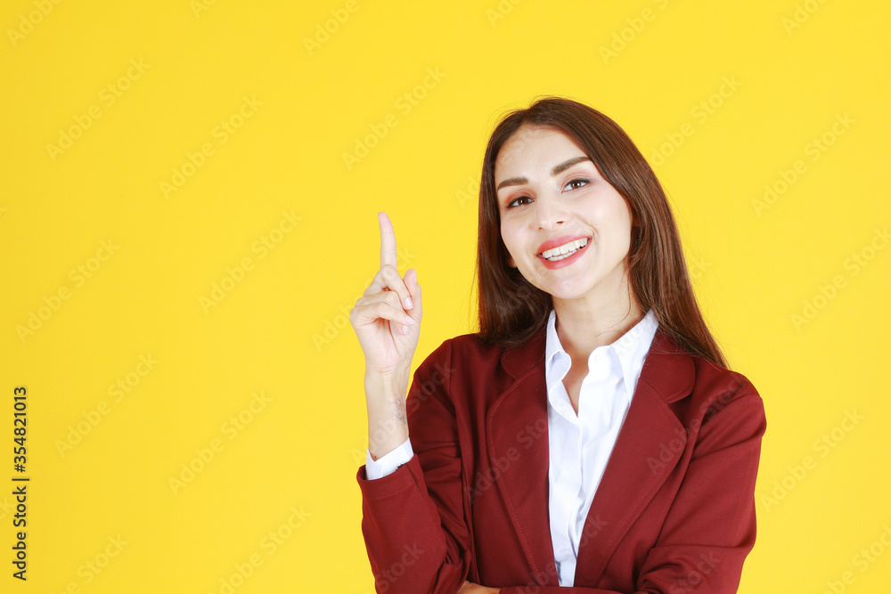 Business Caucasian woman in red suit smiling and thinking for good idea isolated on yellow background. Business Caucasian woman in red suit smiling and thinking for good idea isolated on yellow background.