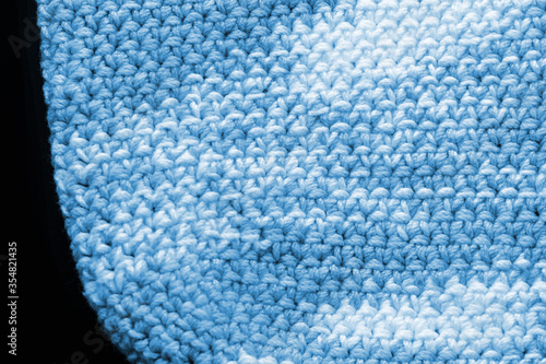 Crocheted fragment of melange yarn close-up. Handmade concept. Abstract background blue color toned