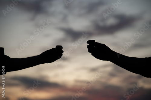 Silhouette of hands on a background of sunset in the mountains