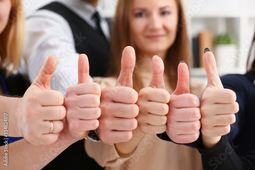 Group of people show OK or confirm with thumb up during conference