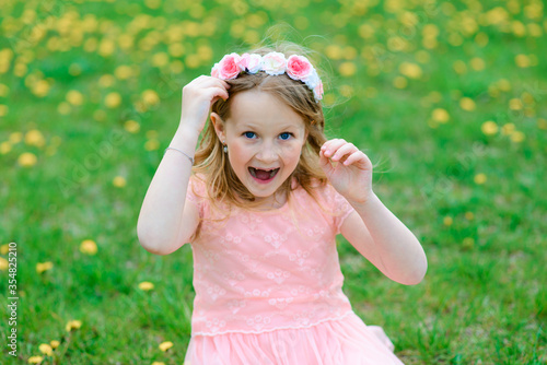 Pretty child girl smiling and playing in flowers of the garden  blooming trees  cherry  apples.
