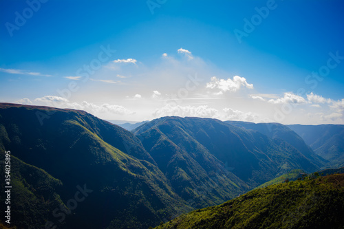 Natural view of the folded mountains and lush green valleys with clear sky and clouds of Cherrapunji  Meghalaya  North East India 
