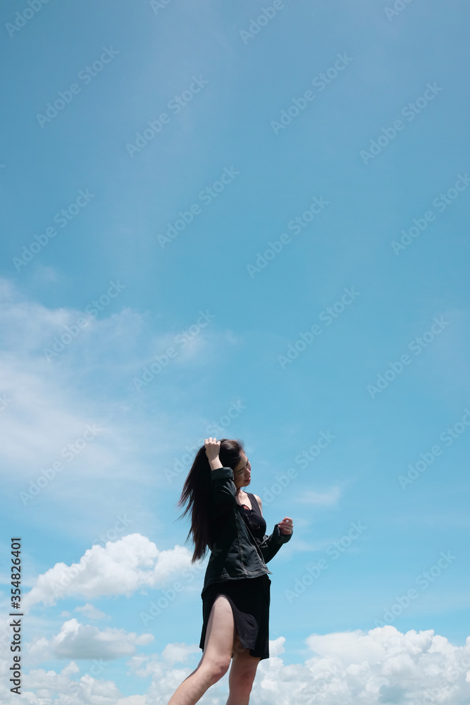 Asian woman long hair standing for freedom and happy in the wind with cloud in the sky. Happiness of life is successful and travel in the world. Copy Space Asian woman long hair standing for freedom and happy in the wind with cloud in the sky. Happiness of life is successful and travel in the world. Copy Space