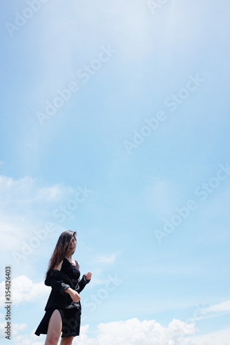 Asian woman long hair standing for freedom and happy in the wind with cloud in the sky. Happiness of life is successful and travel in the world. Copy Space