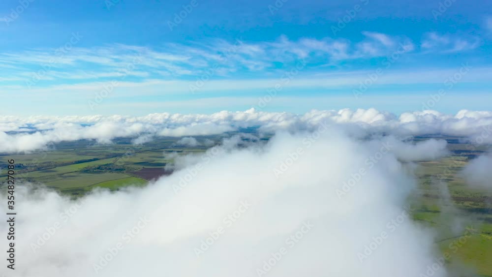 Flying through the fluffy clouds layers. Camera above ground. Amazing timelapse of soft white clouds moving slowly on the clear sky Flying through the fluffy clouds layers. Camera above ground. Amazing timelapse of soft white clouds moving slowly on the clear sky
