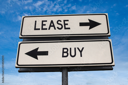 Wallpaper Mural Lease vs buy. White two street signs with arrow on metal pole with word. Directional road. Crossroads Road Sign, Two Arrow. Blue sky background. Concept for own property versus borrow it. Torontodigital.ca