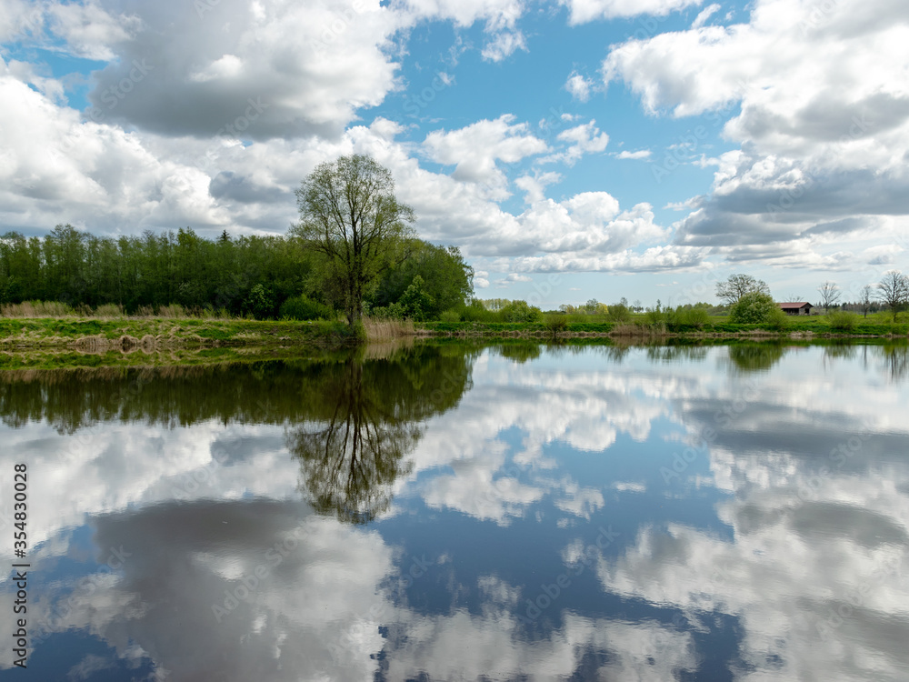 calm scene of beautiful sky with cumulus clouds reflection on the lake