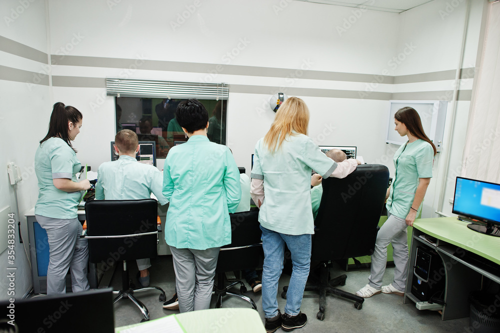 Obraz premium Medical theme.Observation room with a computer tomograph. The group of doctors meeting in the mri office at diagnostic center in hospital.
