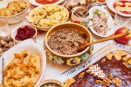 Traditional Ukrainian food. Kutya, borsch, dumplings, cabbage rolls on festive table.