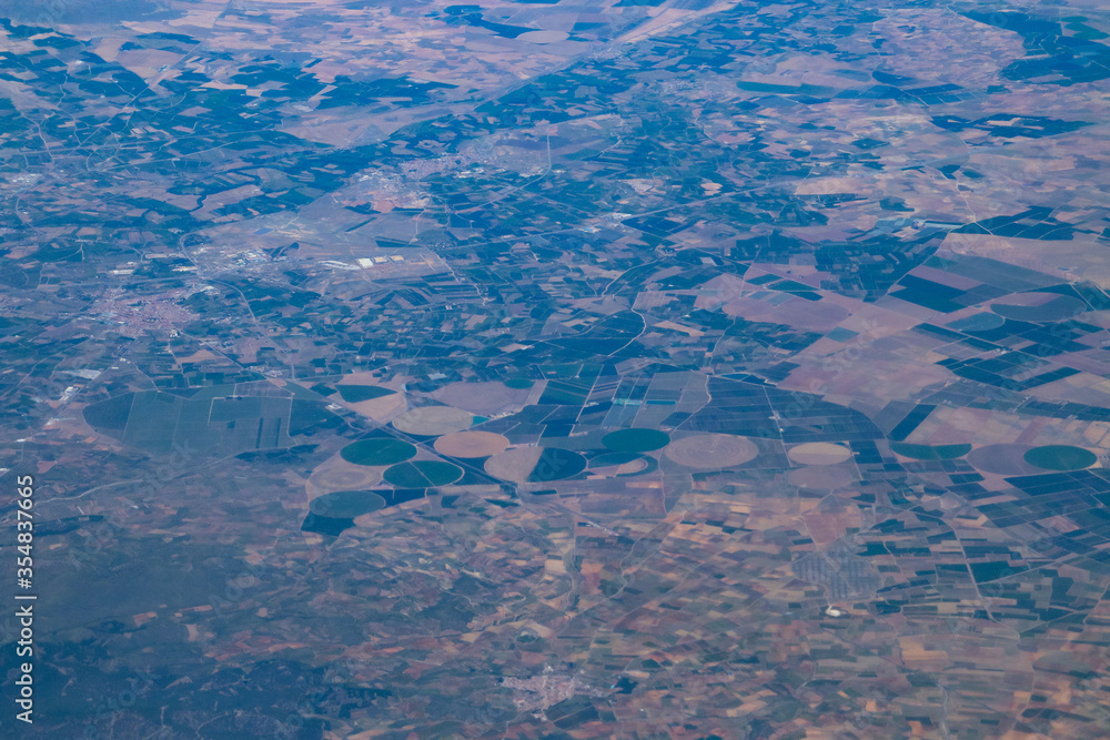 Naklejka premium Campos de cultivo circulares entre Alfamén y Alpartir en Zaragoza, España. Fotografía aérea desde la que se observan las formas poligonales y circulares de distintos tipos de cultivo.