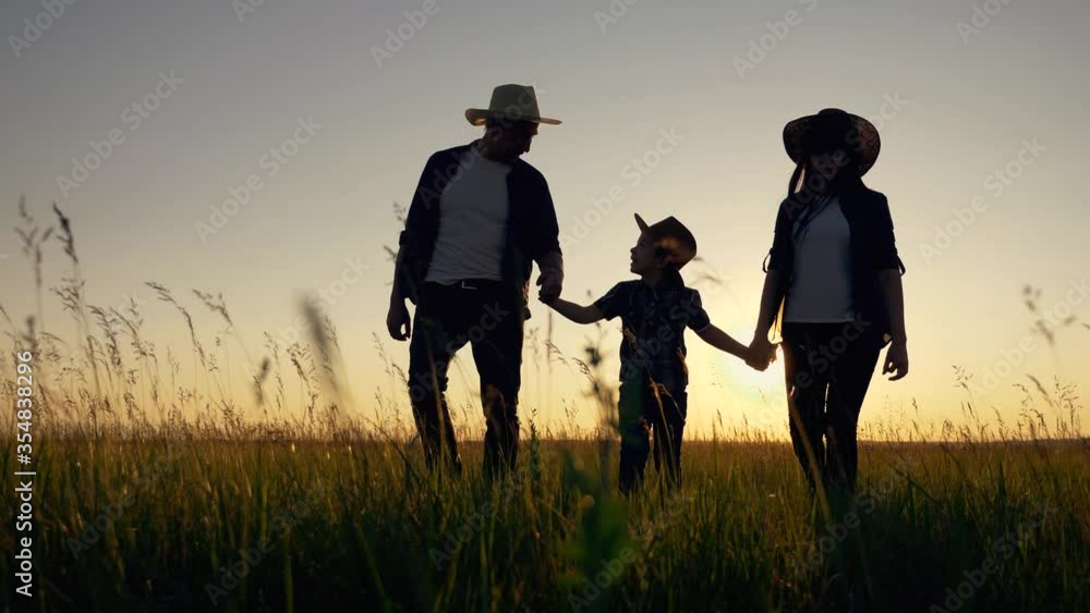 Healthy happy family. Parents father mother son walk in a wheat field in the evening sunset. The concept of fatherhood, motherhood, friendship, teamwork. Healthy happy family. Parents father mother son walk in a wheat field in the evening sunset. The concept of fatherhood, motherhood, friendship, teamwork.
