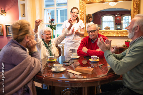 Senior woman celebrates a board game win