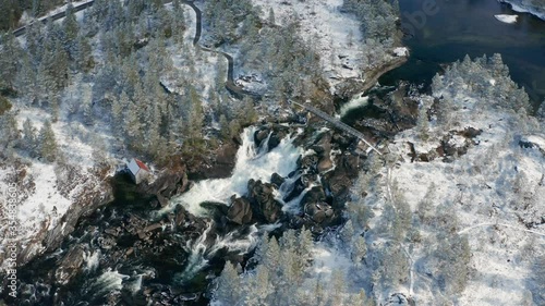 Wallpaper Mural Aerial view of the Likholefossen waterfall on the Gaula river in Norway. A turbulent mass of water rushing down in the narrow rocky watercourse. A narrow steel bridge hangs above the waterfall. Torontodigital.ca