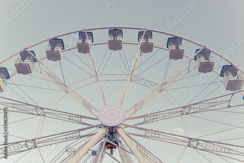 Background with a part of ferris  lights and blue sky. Beatiful background with ferris. Blue  light  white  sky  ferris wheel. Vintage style.