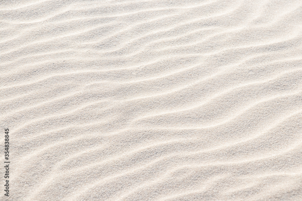 Beautiful light sand texture. Wave texture on the sand. Sandy beach for a background. Top view. Beautiful light sand texture. Wave texture on the sand. Sandy beach for a background. Top view.