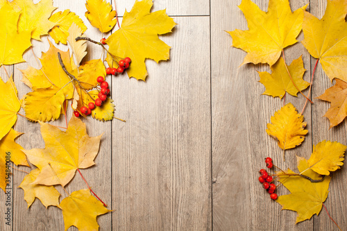 Colorful autumn leaves over wood background with copy space