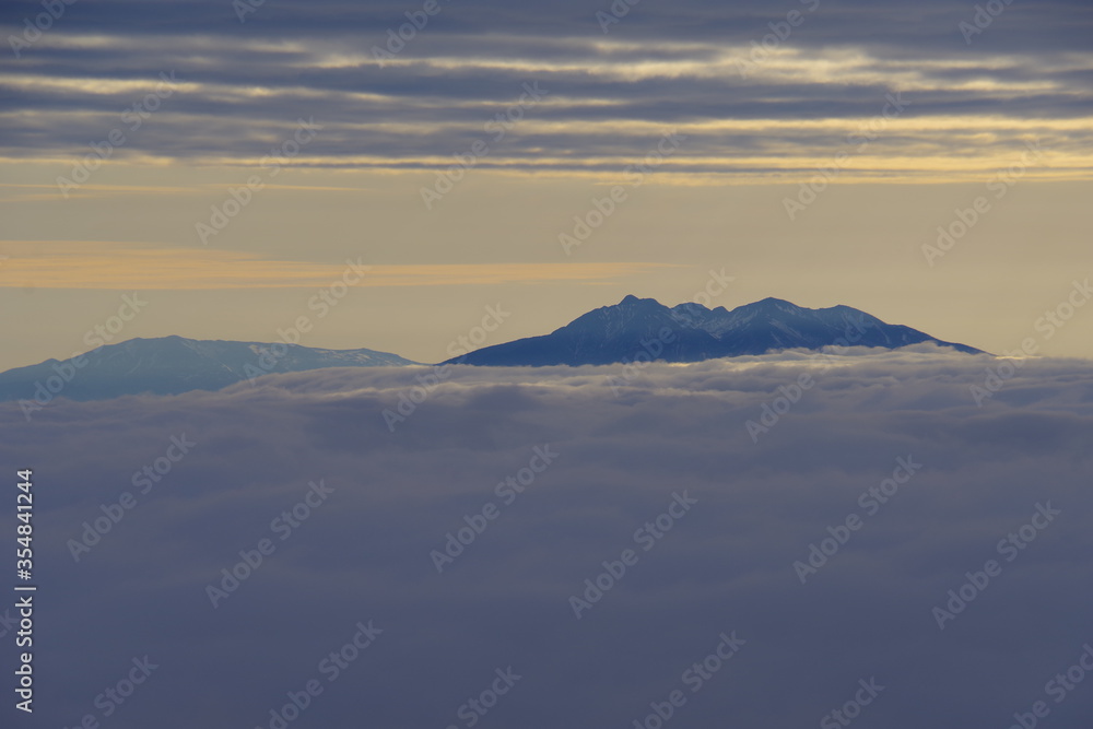 雲海の彼方に頂きを見る山。北海道、日本。
