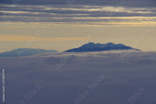 雲海の彼方に頂きを見る山。北海道、日本。