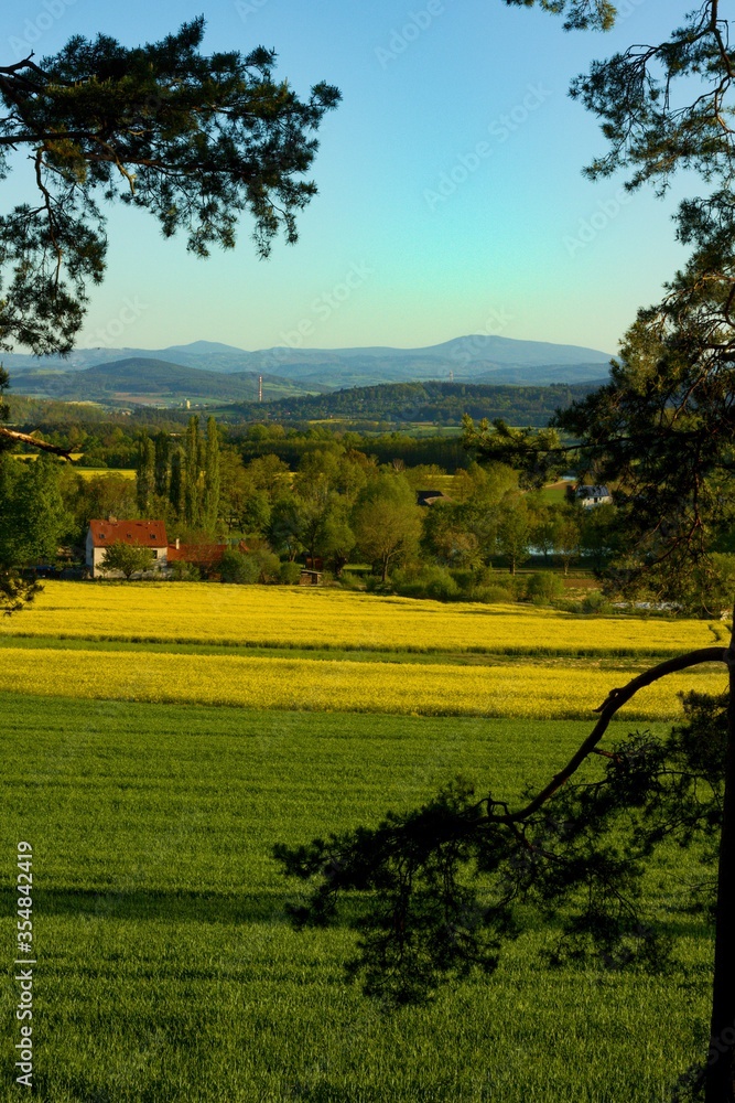 Obraz premium Typical panoramic preserved spring rural country landscape with small village of South Bohemia, Czech Republic