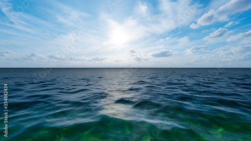 Aerial view of dark blue ocean and light blue sky.