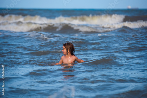 Kid boy playing and having fun on the beach on blue sea in summer. Travel lifestyle, swimming on sea summer camp. © Volodymyr