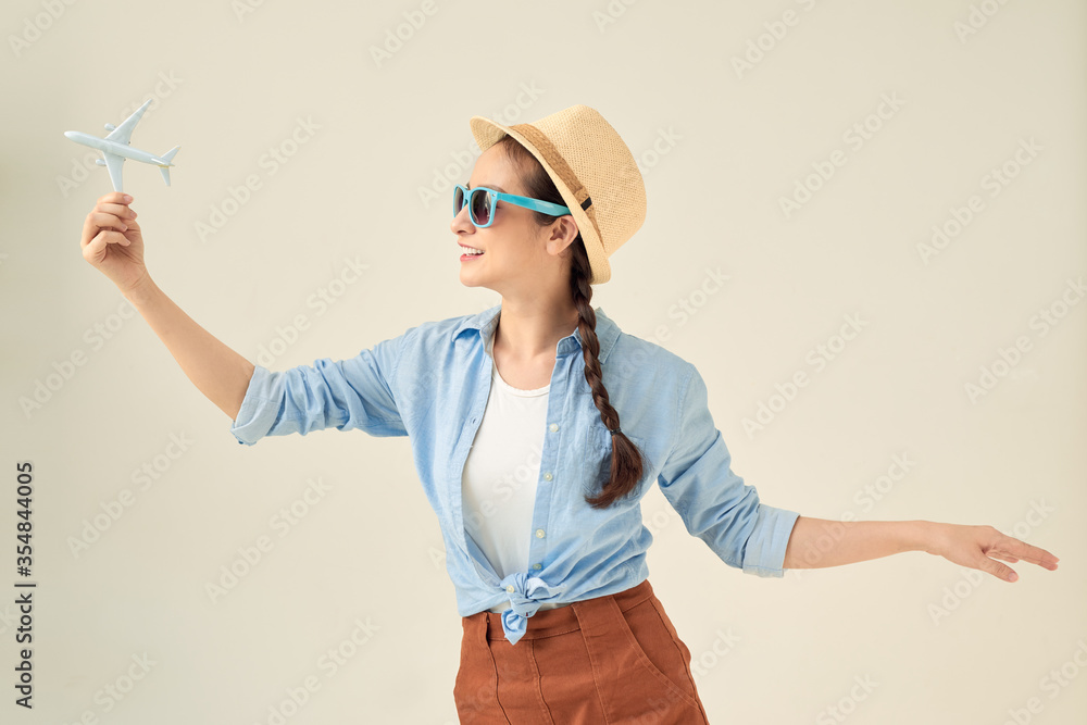 Portrait of young happy woman holding jet aircraft on white background. Advertisement banner for transport companies Portrait of young happy woman holding jet aircraft on white background. Advertisement banner for transport companies